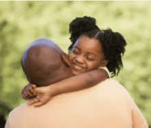 A Black father and daughter hugging