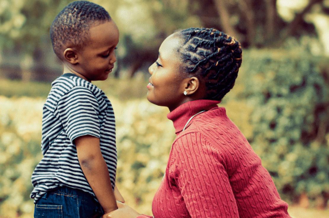 Mother smiling holding her child's hand.