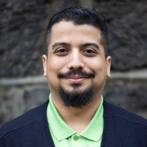 Richard Amador, a Hispanic man with a goatee, smiles at the camera