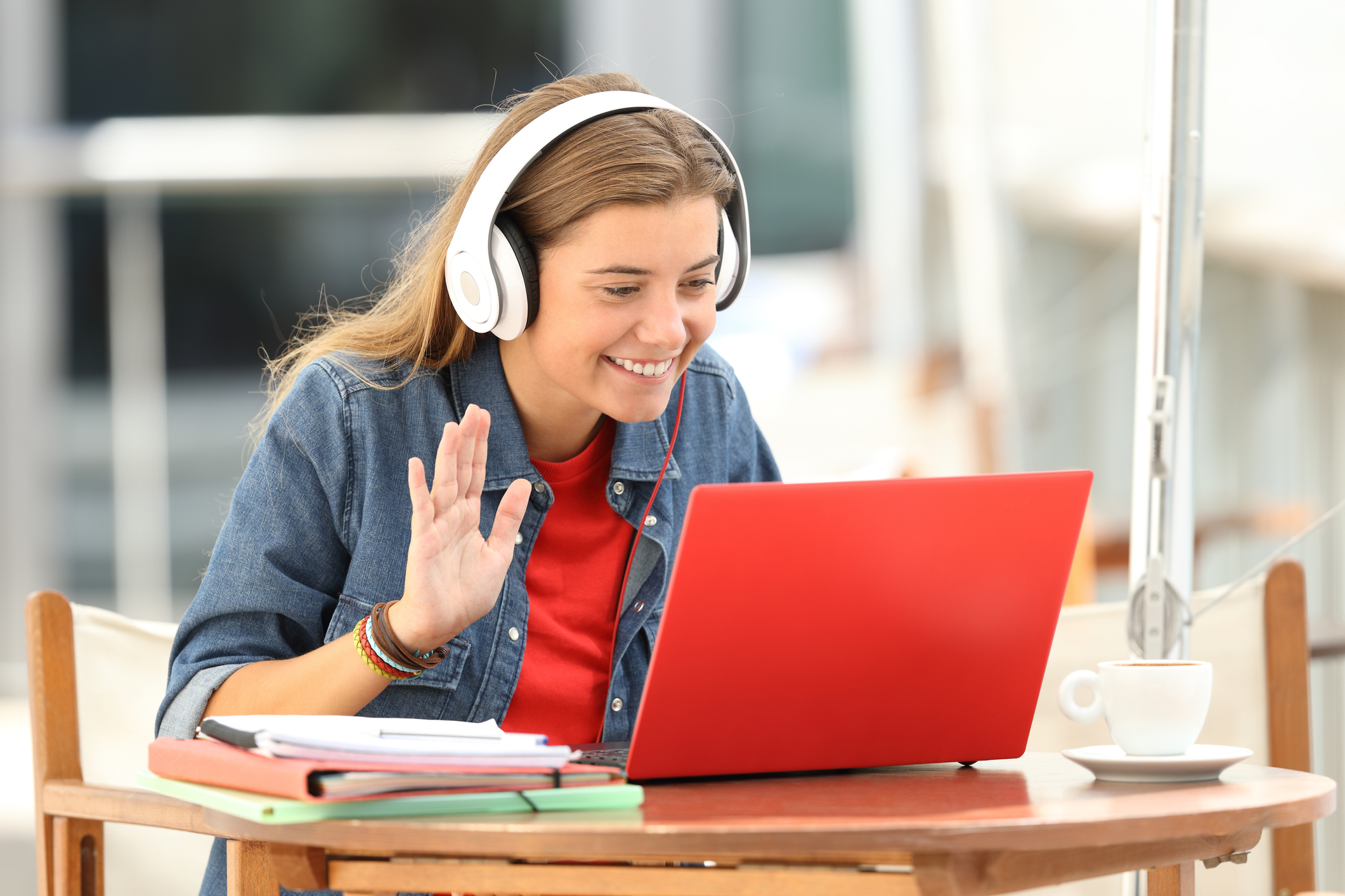 stock photo of a white female college student on a zoom call using her laptop