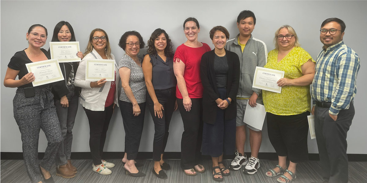 Community Health Workers hold their certificates of completion and pose for a group photo with instructors, after completing the Center's Health Literacy for CHWs training series.
