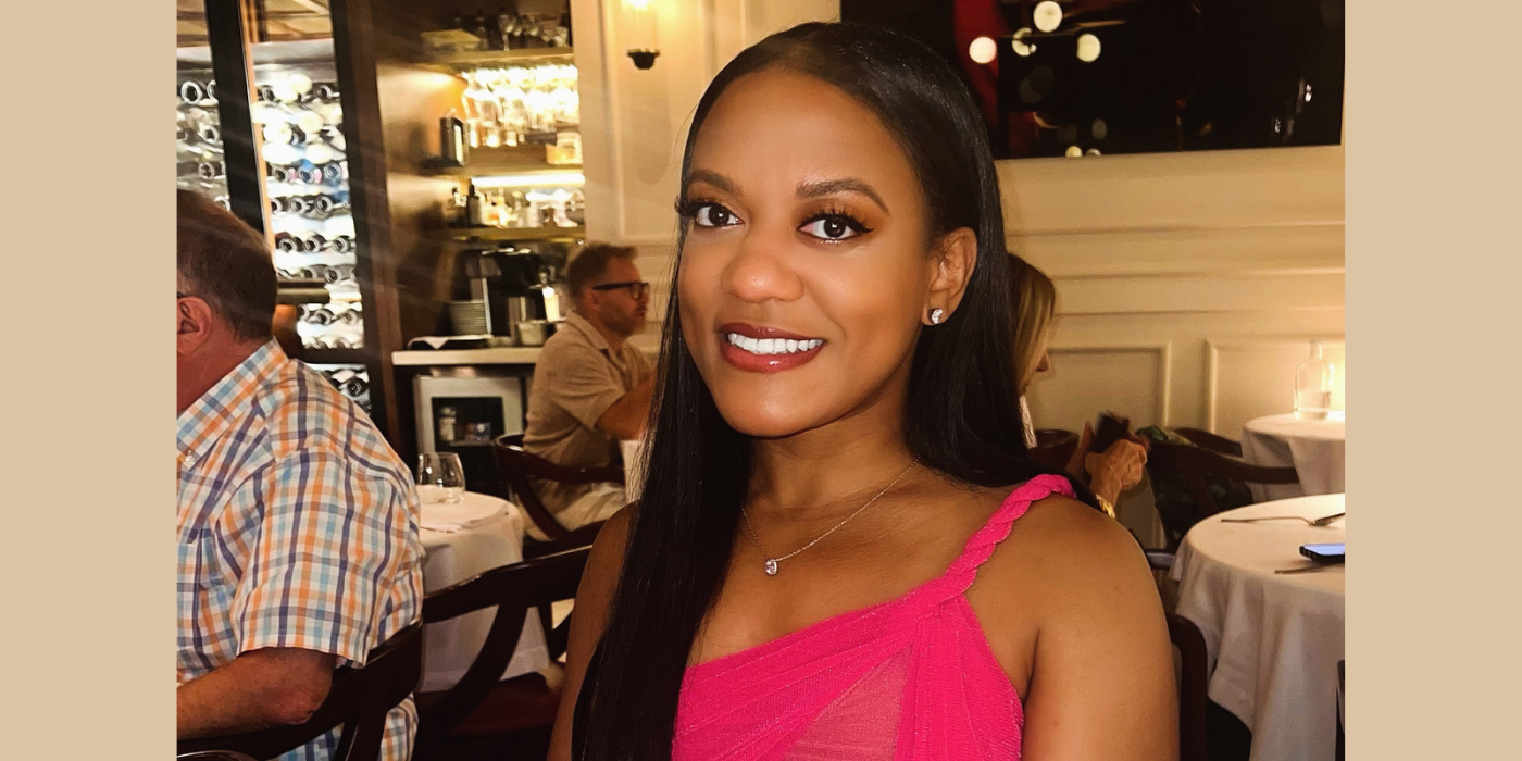 black woman with long black hair wearing a pink top