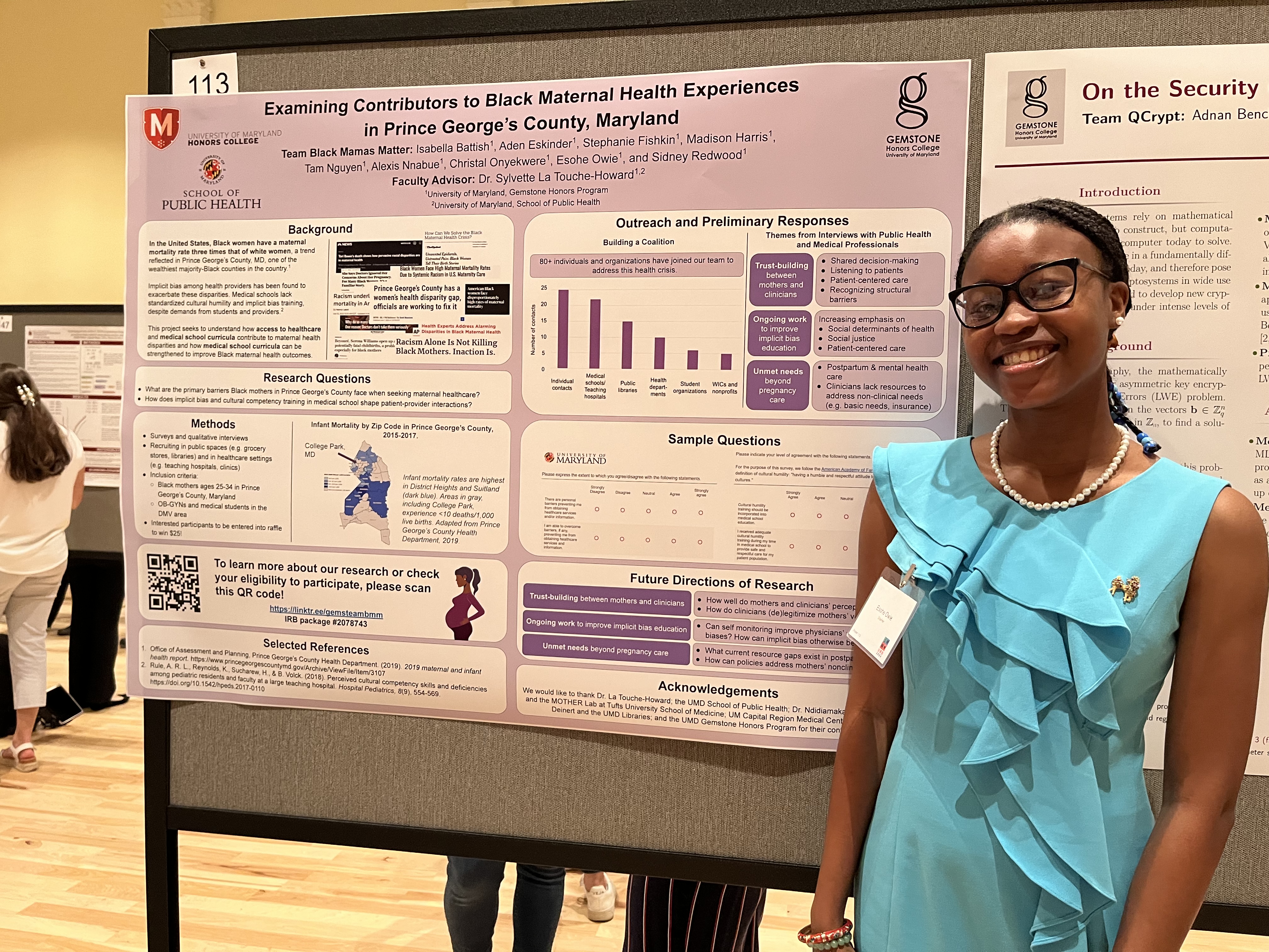 Grad student smiles in front of public health poster board