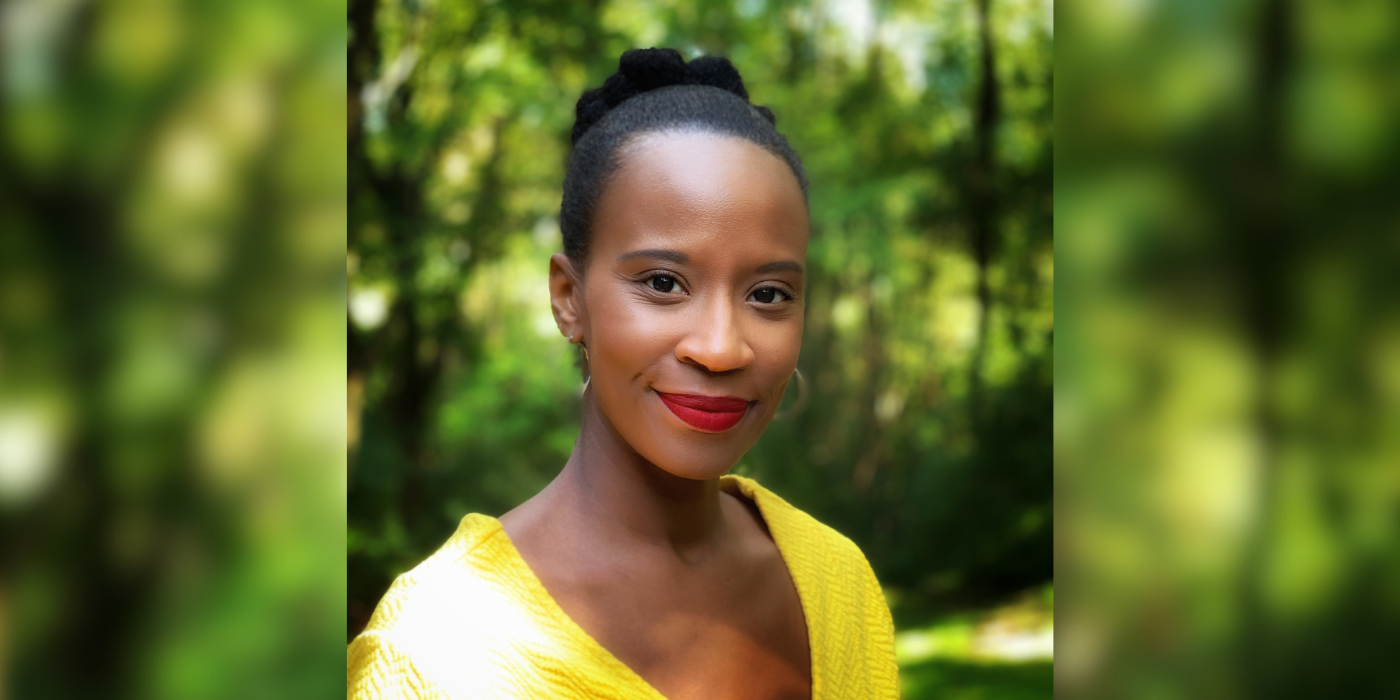 Headshot image of a black woman with a yellow business shirt on