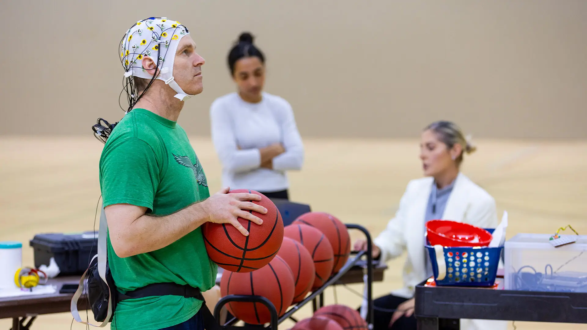 John Tucker lining up for a free throw, with an EEG cap on his head with wires to analyze brain activity