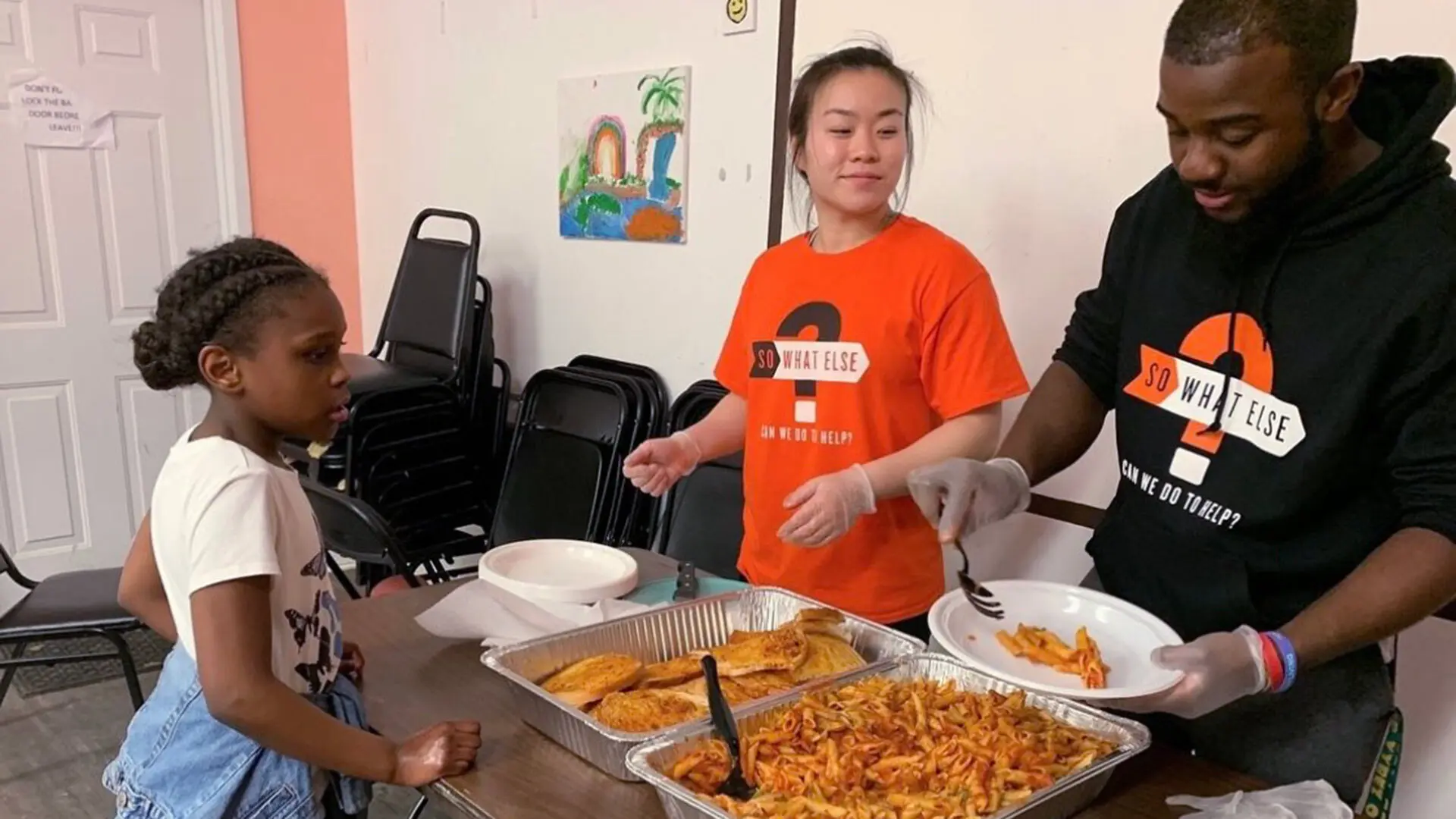 Maryland Food Bank Student volunteers serving a little girl a meal