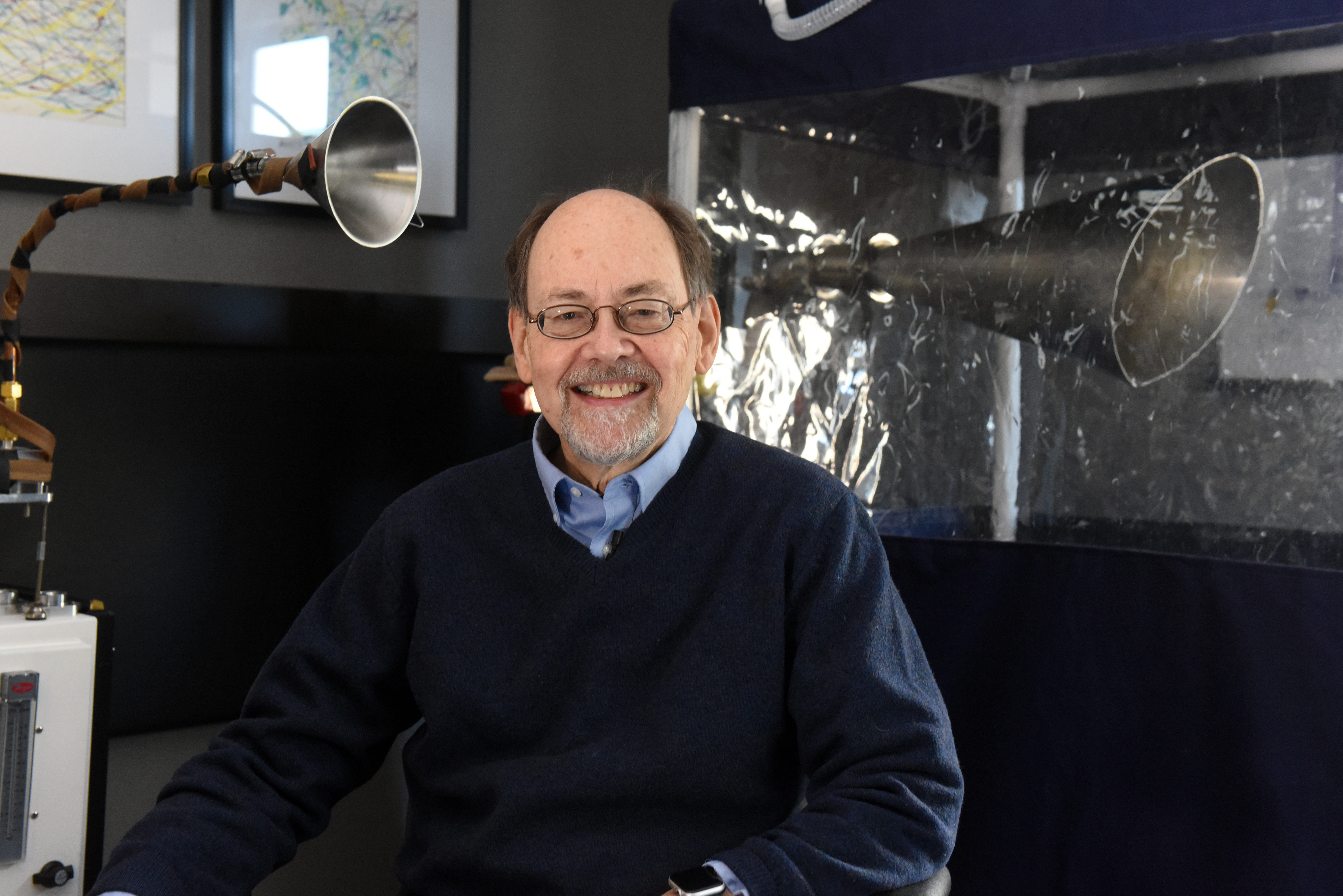Dr Donald Milton smiles to camera in front of machine