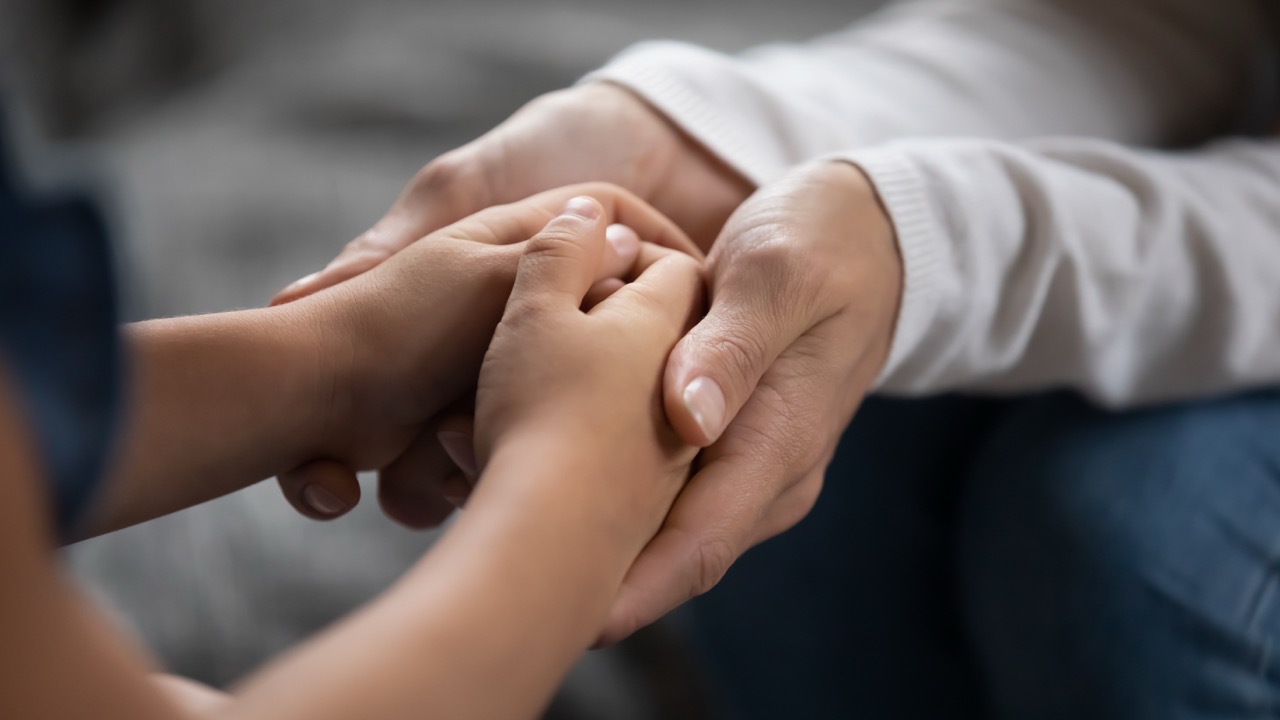 adult hands hold child's hands