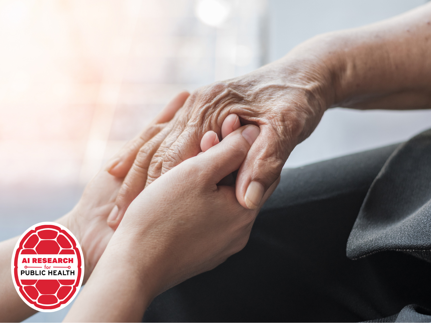 two youthful hands hold an older person's hand