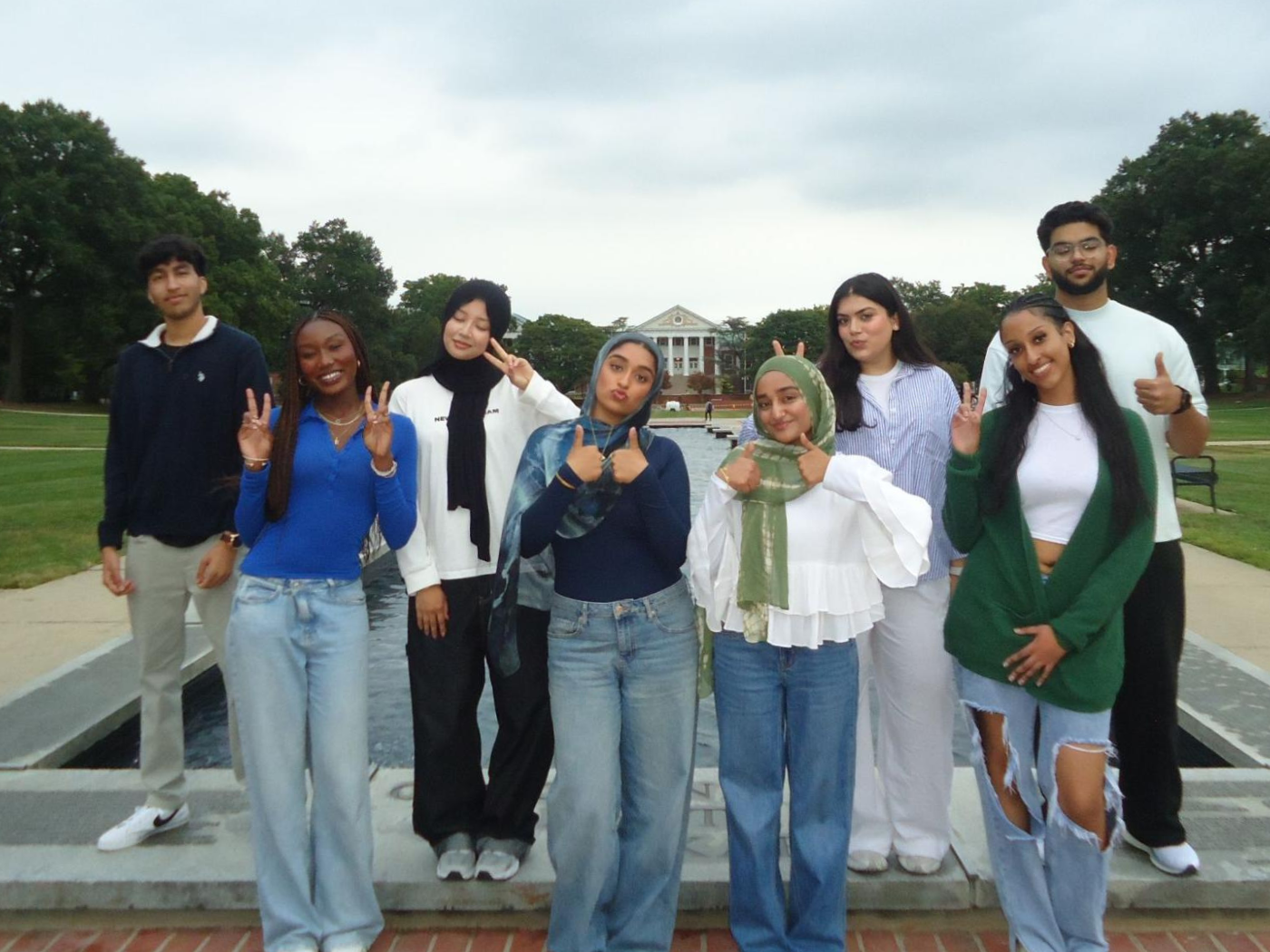 student group of young men and women, some wearing headscarfs smile to camera at UMD
