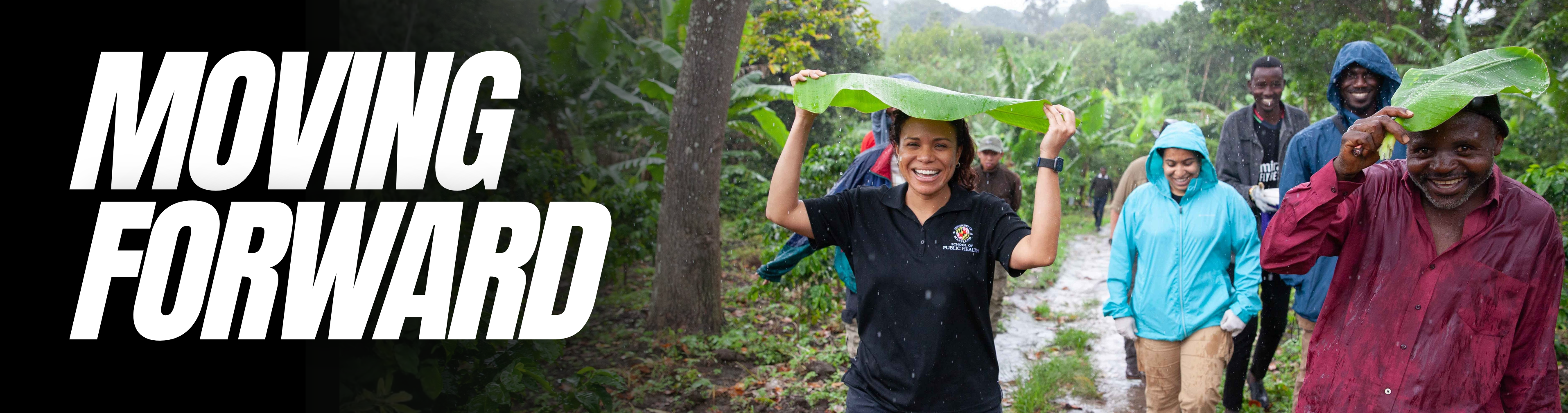 Woman in the rain holding a giant leaf above her head while smiling