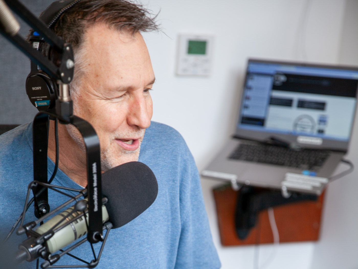 Professor and DJ speaks into the mic at a radio