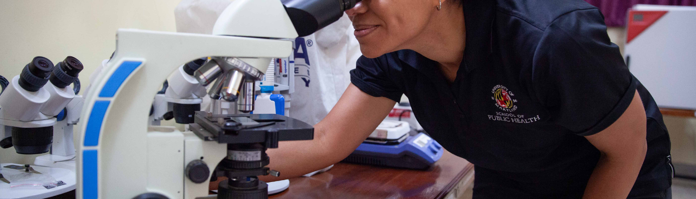 female scientist looking though microscope
