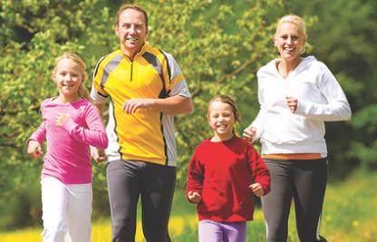 Family of 4 running in a sunny day 