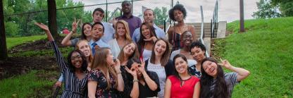 Large, diverse group of Behavioral Community Health students posing for a group picture outside of the School of Public Health building.