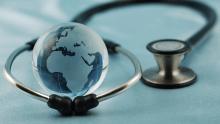 Globe wrapped in a stethoscope, representing global health.