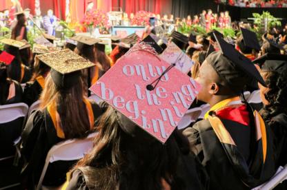 Graduates in caps and gowns seated during a commencement ceremony.