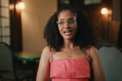 black woman with glasses being interviewed for a documentary