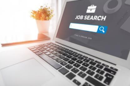 Laptop displaying a job search webpage with a search bar and briefcase icon.