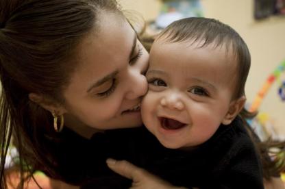 Woman kissing smiling baby