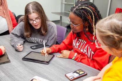 Students looking at a tablet in a classroom
