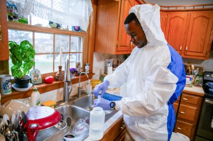 male student conducting research in a home, testing water supply