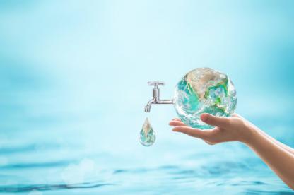 Conceptual image of a hand holding the Earth beside a dripping water faucet, symbolizing global water conservation and access to clean water.