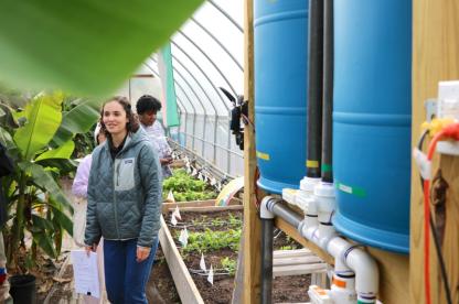female student inside a large green house
