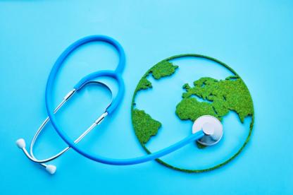 Blue stethoscope placed over a green-and-blue globe, symbolizing global health and healthcare around the world.