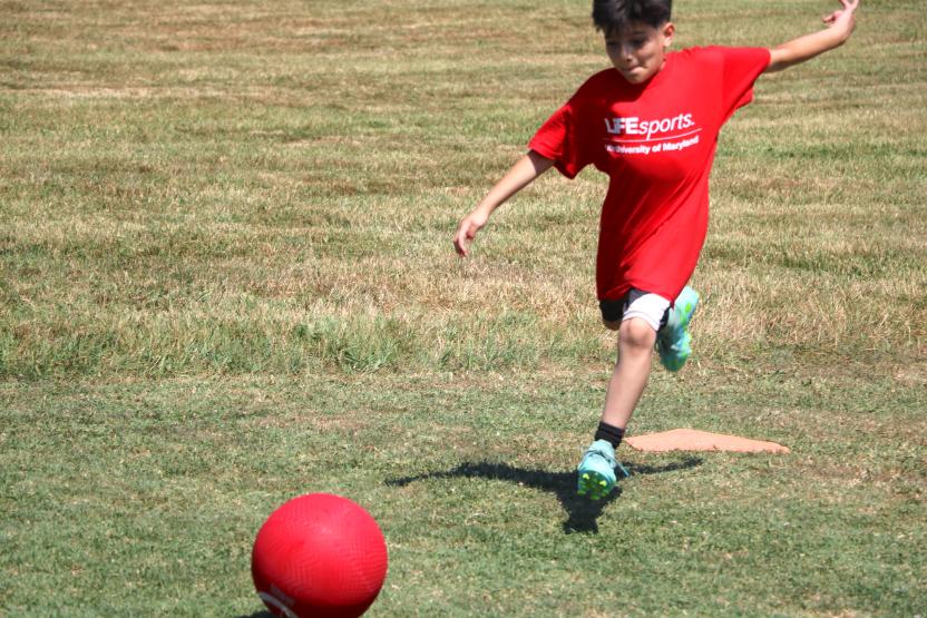 Kid kicking a kickball