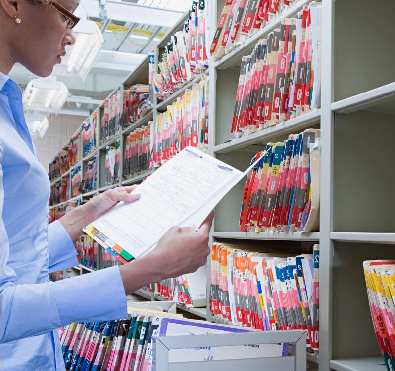 Woman reading patient's file in the hospital's administration department.