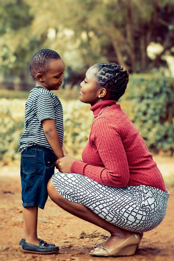 Mother smiles at her child during an outdoor moment.