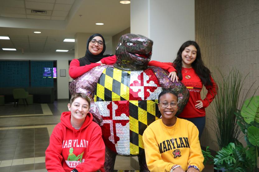 students posing by testudo statue