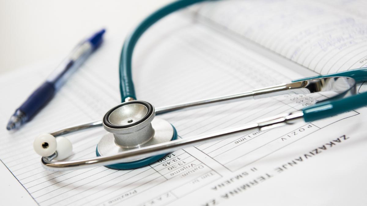 Stethoscope sits on top of medical chart with pen