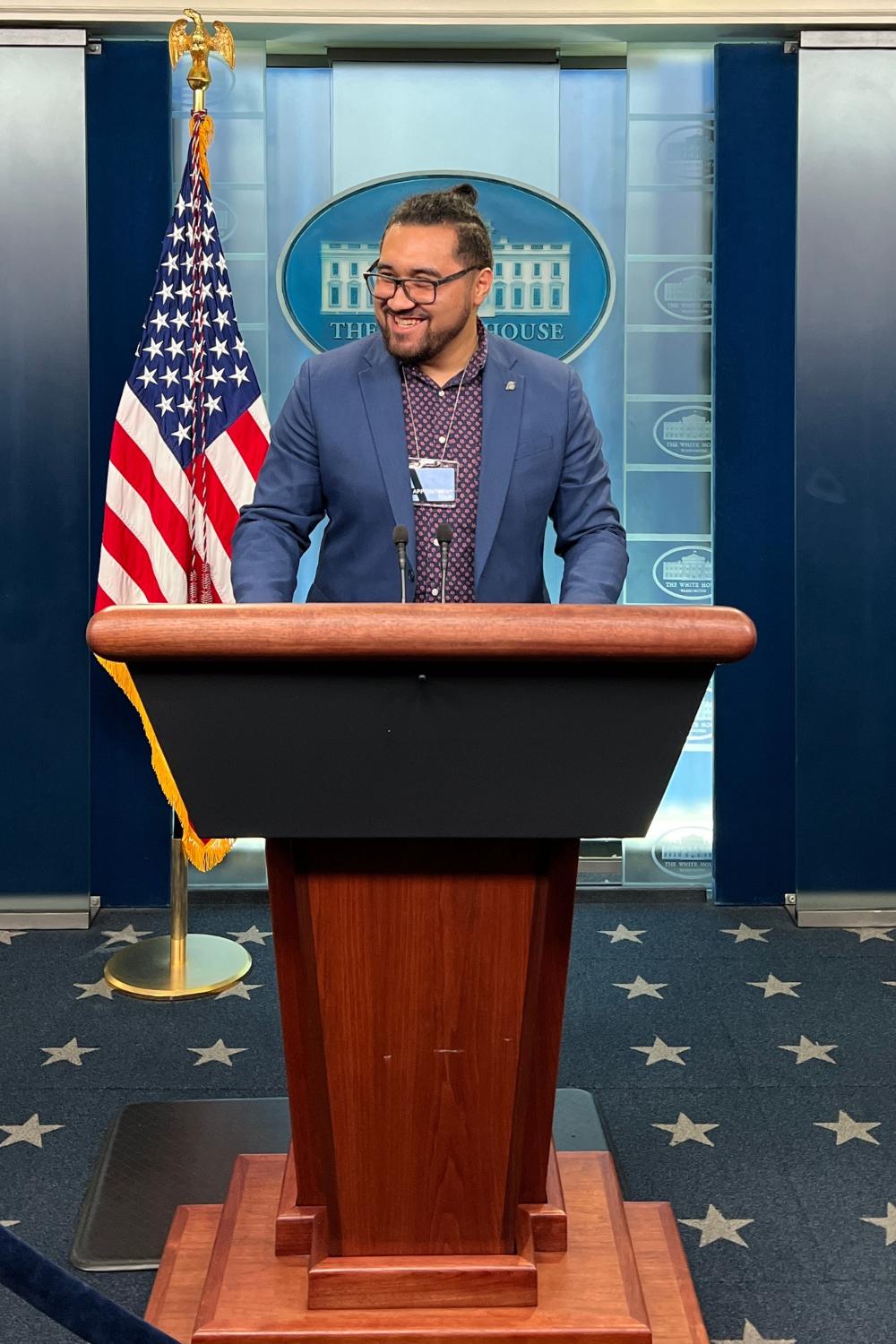 Alum stands at White House podium