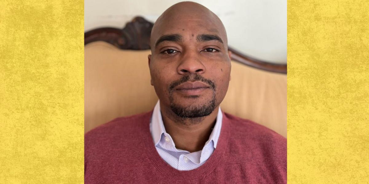 Black doctoral student headshot wearing red sweater