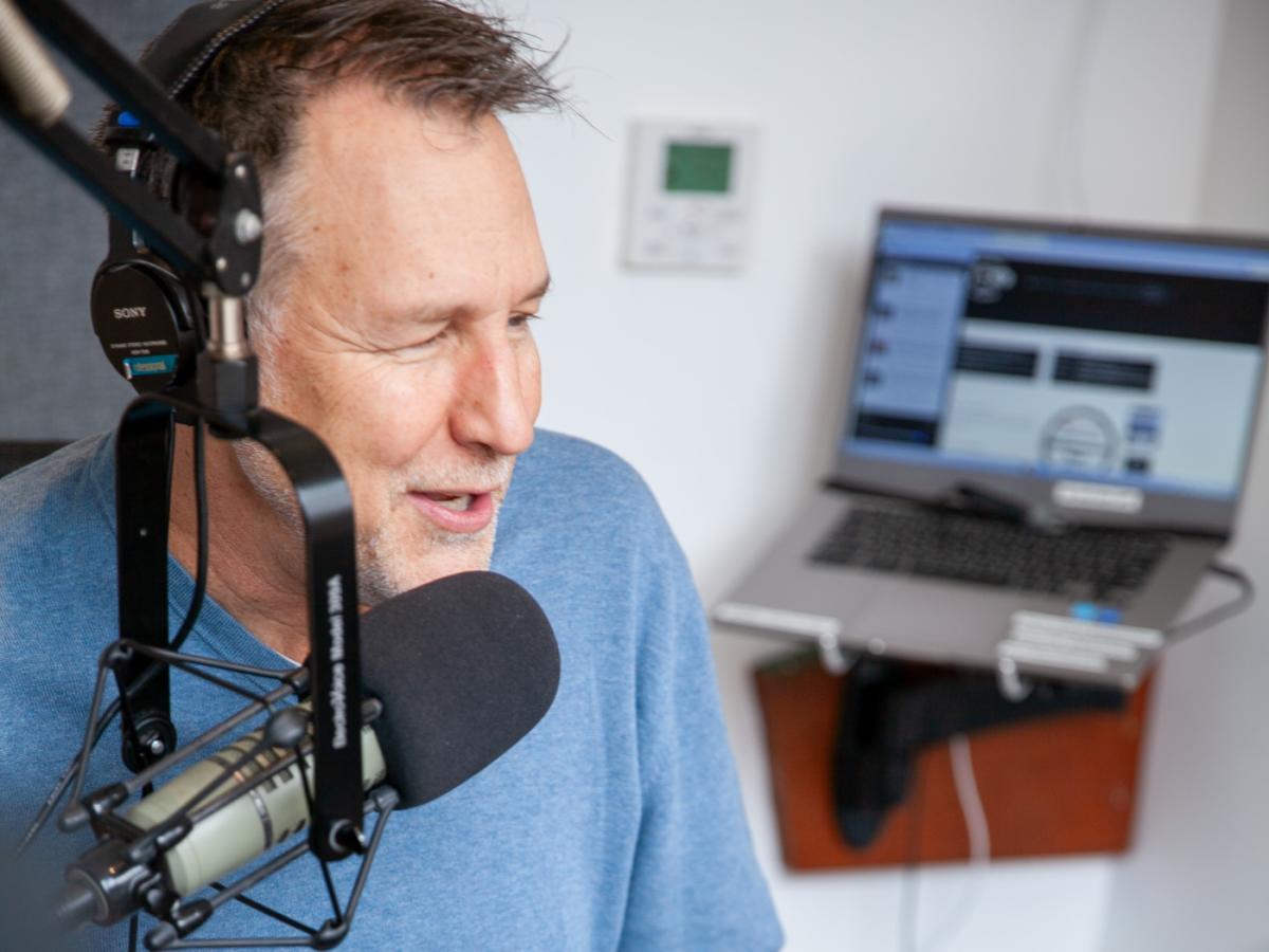 Professor and DJ speaks into the mic at a radio