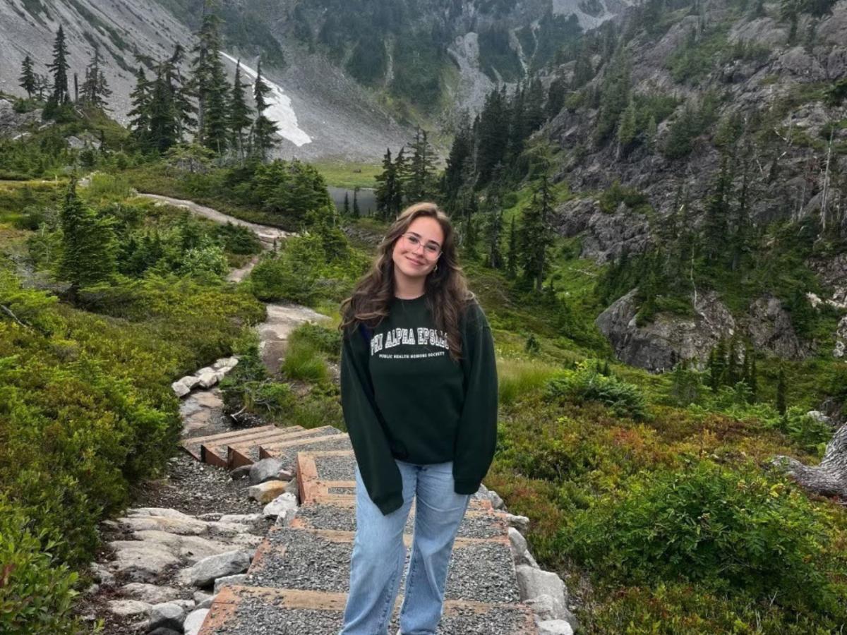 woman standing in mountain area, smiling