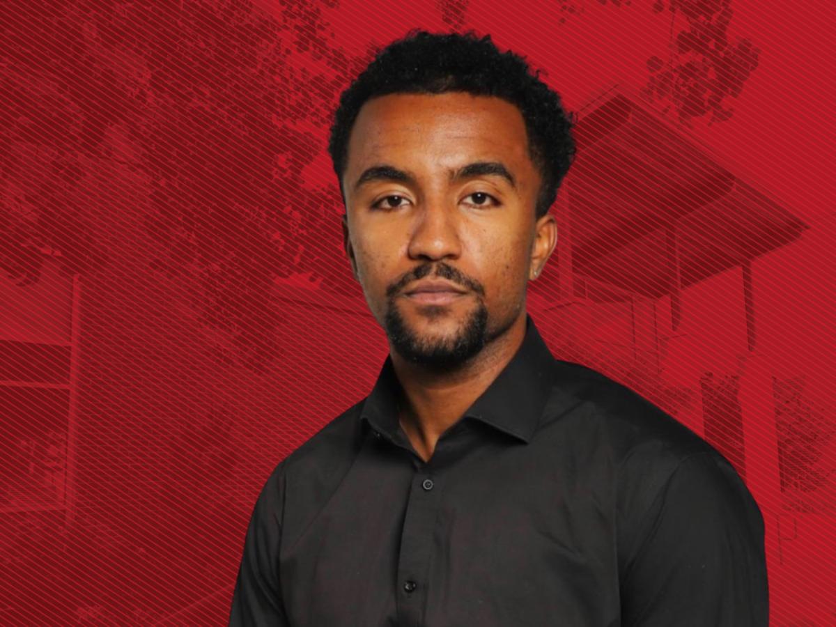 Black male grad student in dark grey shirt with goatee in front of red graphic background
