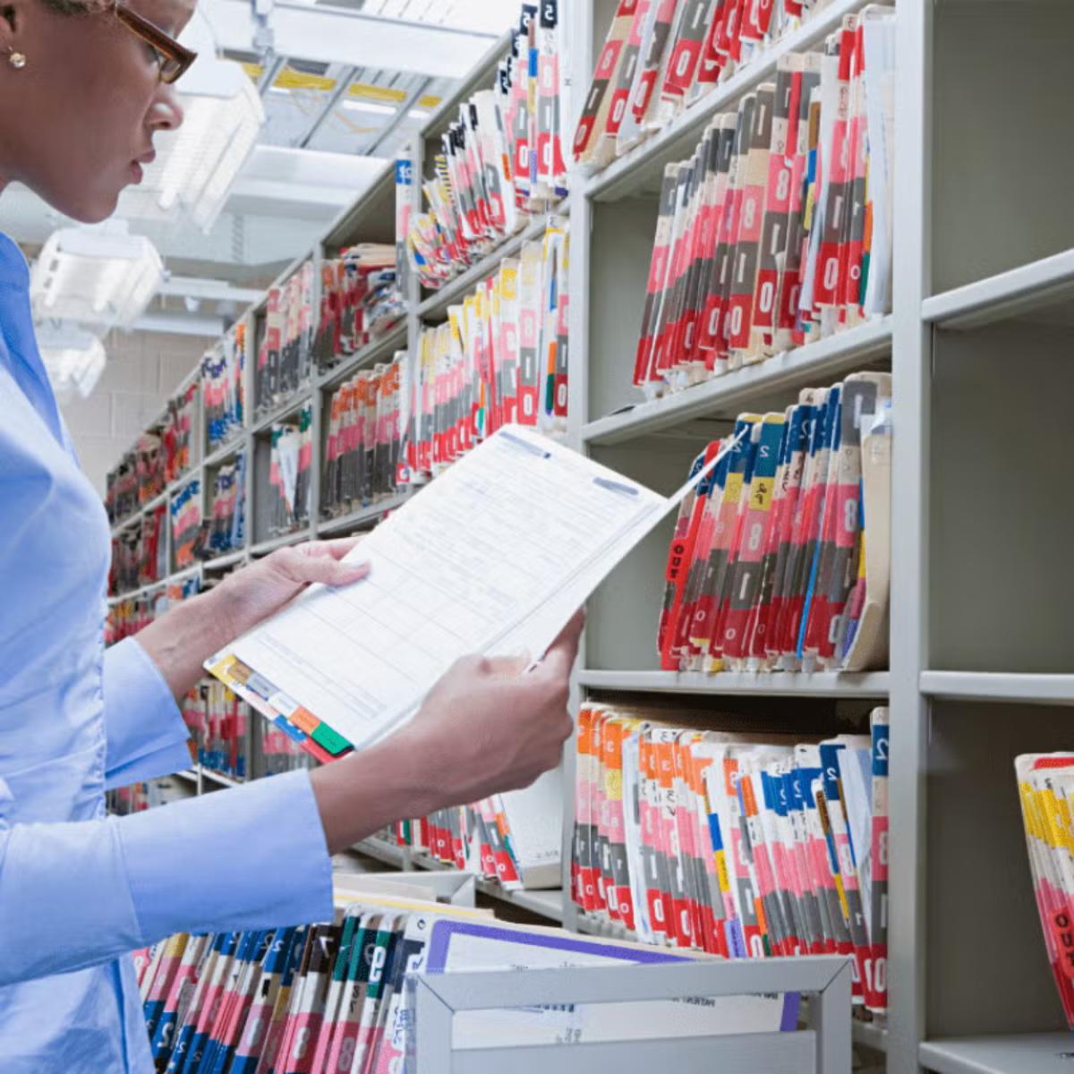 Woman reading patient's file in the hospital's administration department.