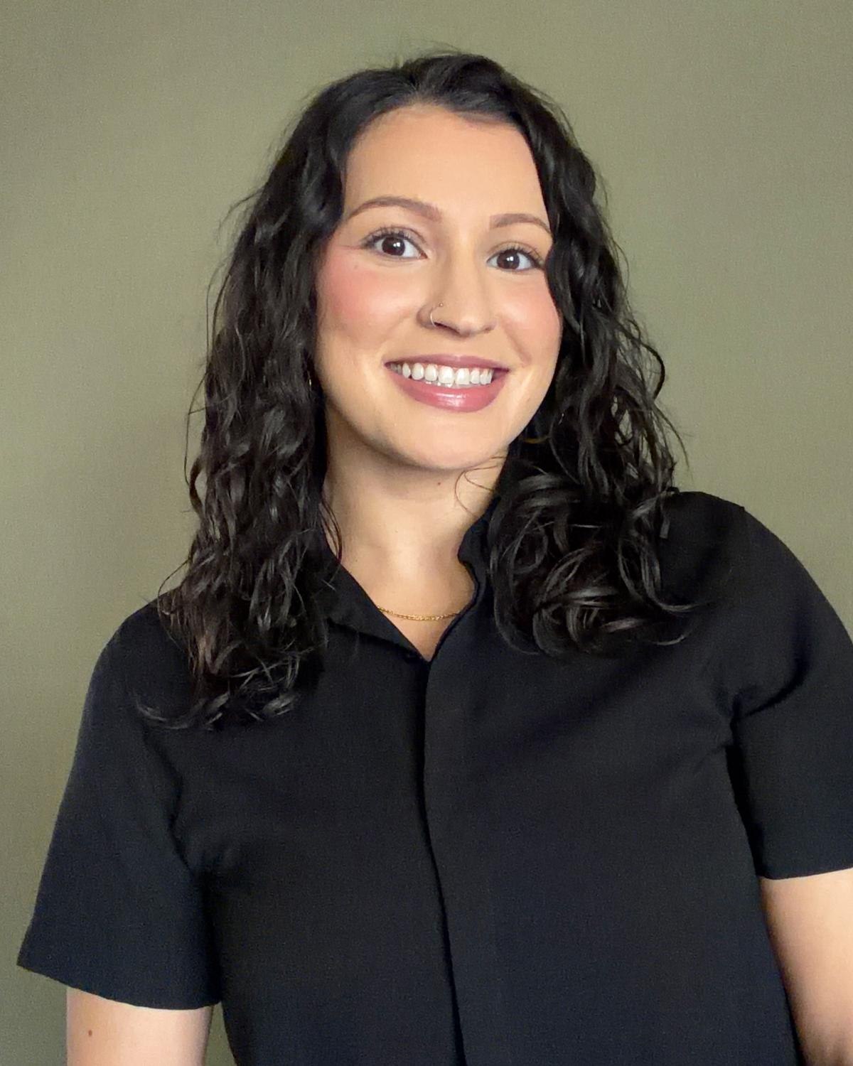 Brown haired woman looking at camera smiling.