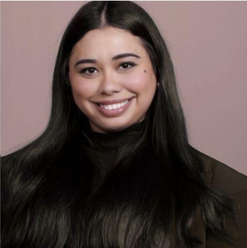 Woman smiling at camera wearing all black with brown hair and eyes. 
