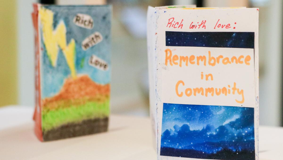 Two 'zines stand up on a white surface, blurry background