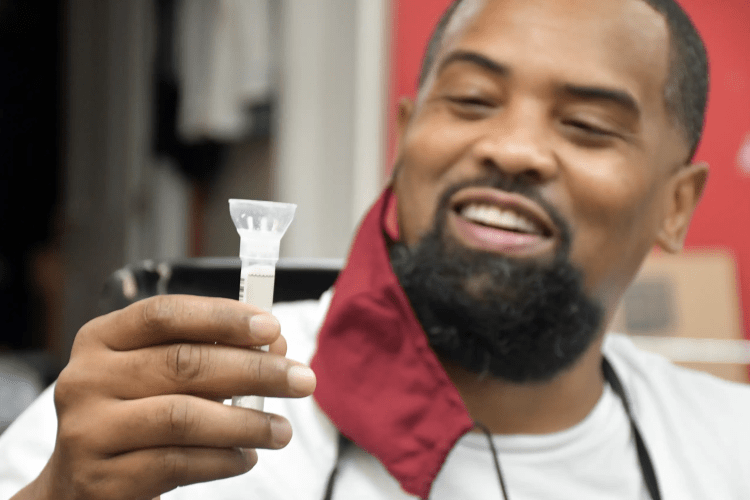 Man in barbershop holding testing specimen