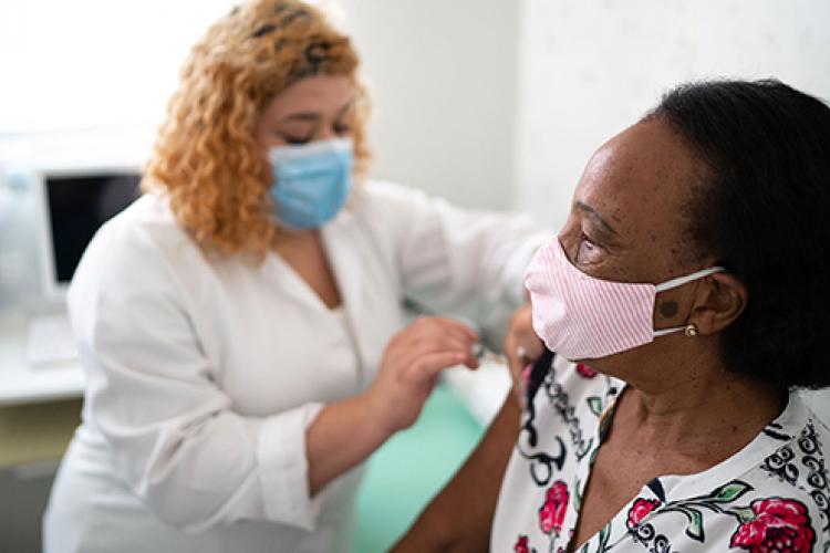 Woman receiving shot from health care worker