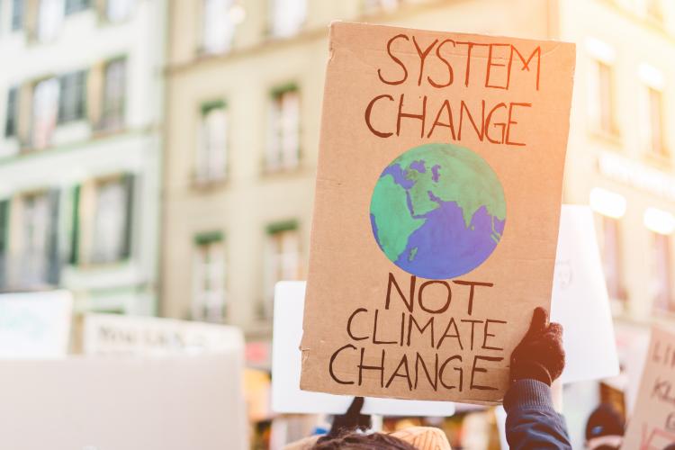 Protest sign reading system change not climate change