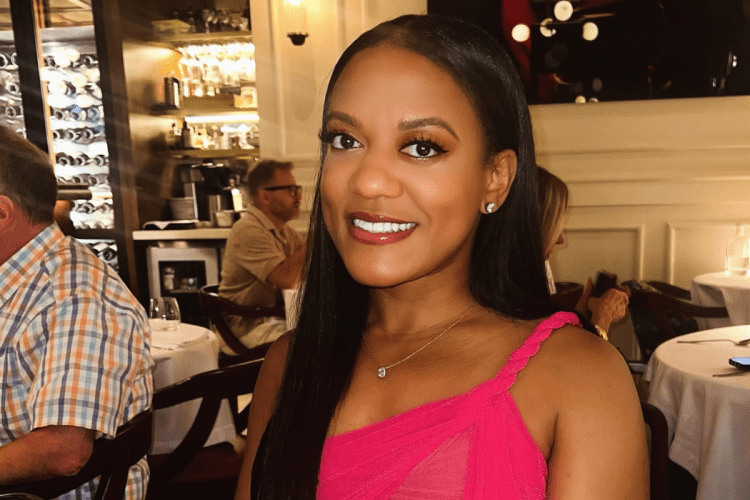 black woman with long black hair wearing a pink top