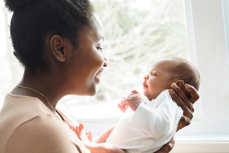 black mother cooes at newborn baby