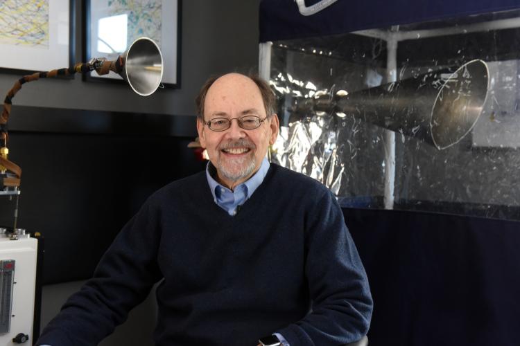 Dr Donald Milton smiles to camera in front of machine