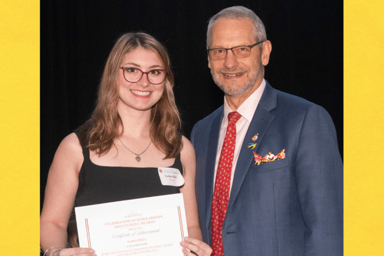 Female student posing with award certificate